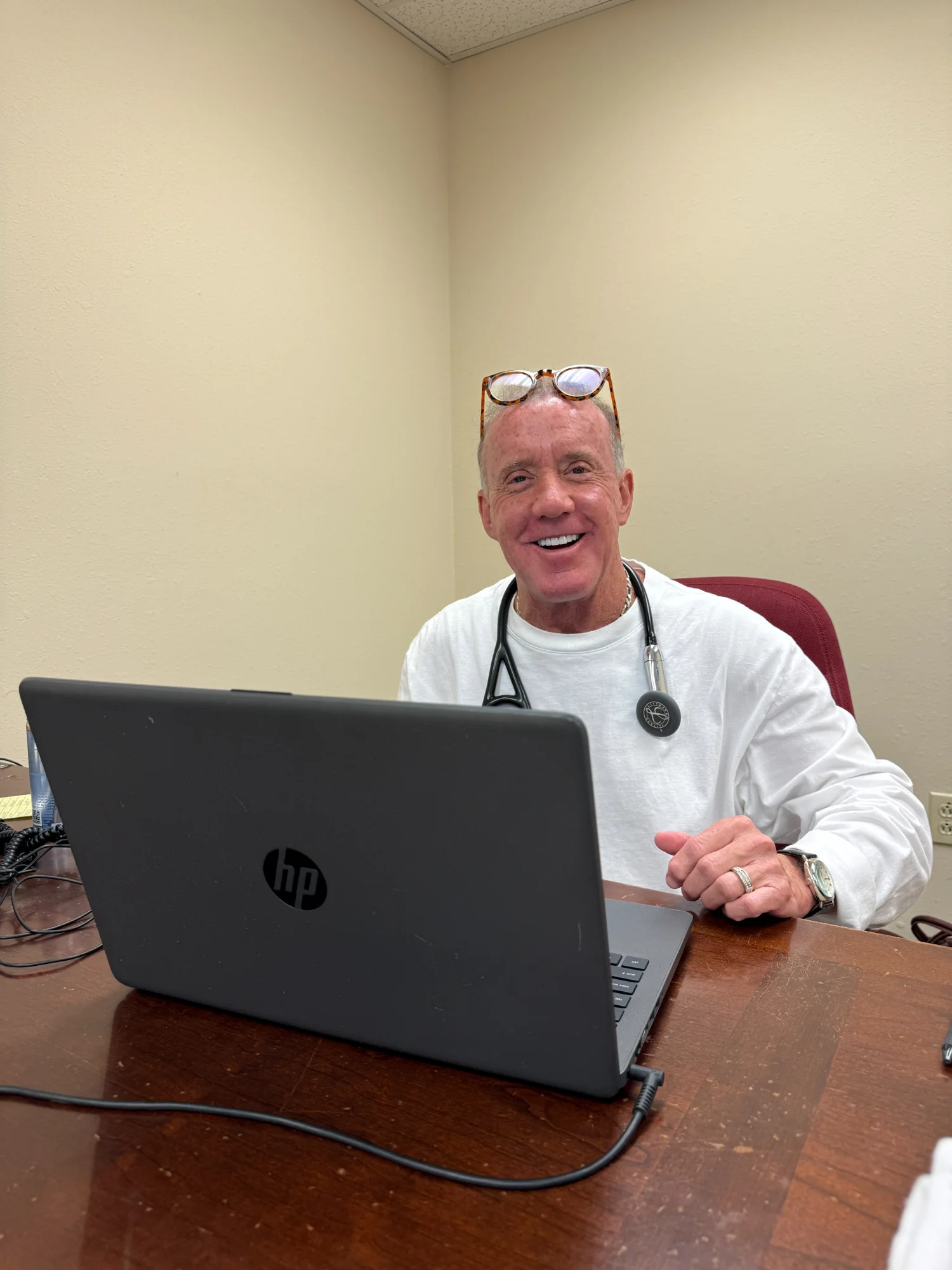 Dr. Jeffrey Tauth at his desk in the Hot Springs clinic, wearing a stethoscope.